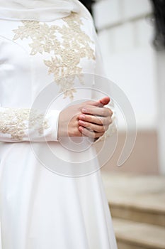 Hands of the bride. White dress for nikah, muslim wedding. Shy girl.