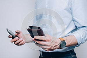 Hands with brown wallet and smartphone