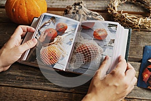 Hands browsing photo album with autumn printed photos.