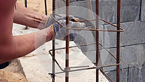 Hands Builder In Dirty Gloves Tied Steel Wire On Rebar Tool On Construction Site