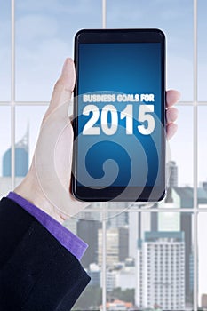 Hands with business goals on smartphone