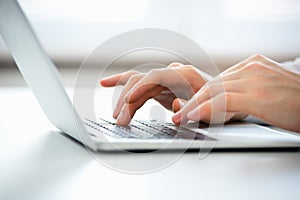 Hands of business man typing on a laptop.