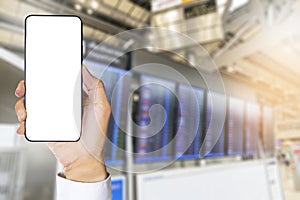 Hands of a business man wearing a white shirt holding a mobile phone on airport. Mobile with white screen for putting banners