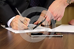 Hands of business men and women studying the documents