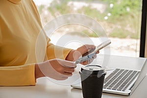 The hands of business people holding credit cards and smartphones for online shopping and paying via the internet