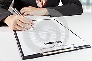 Hands of business woman signing the agreement document with pen