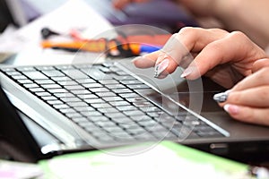 Hands of business woman working on laptop