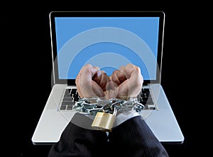 Hands of businessman addicted to work bond with chain to computer laptop in workaholic