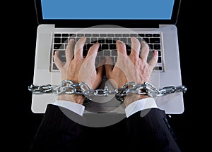 Hands of businessman addicted to work bond with chain to computer laptop in workaholic