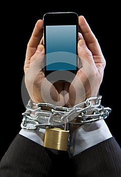 Hands of businessman addicted to work chain locked in mobile phone addiction