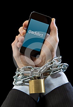 Hands of businessman addicted to work chain locked in mobile phone addiction