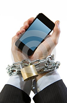 Hands of businessman addicted to work chain locked in mobile phone addiction