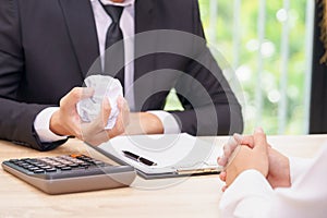 Hands of businessman crumple agreement in font of partner - fail