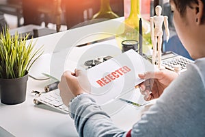 hands of Businessman holding Rejection Letter on desk top at home office . selective focus