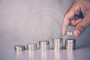 Hands of businessman put coin stack with increase growth, finance and saving.