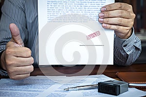 Hands of businessman stamp on paper document to approve business investment contract agreement