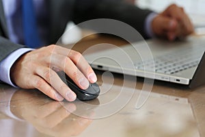 Hands of businessman in suit holding computer wireless mouse