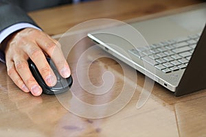 Hands of businessman in suit holding computer wireless mouse