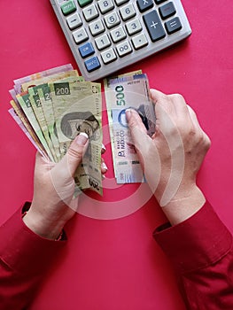 hands of a businesswoman counting mexican banknotes