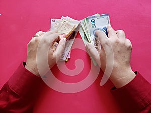 hands of a businesswoman holding mexican banknotes