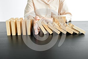 Hands of businesswoman stop block a wood game, gambling placing a wooden block. Concept Risk of management and strategy plan,