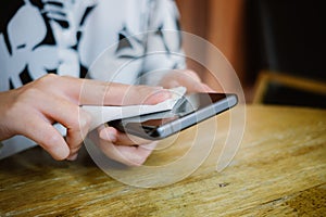 Hands of businesswoman using alcohol fabric cleaning blank screen mobile phone for clearing covid-19 virus. image for healthy,