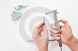 Hands with a caliper measure bolts and nuts. on white background