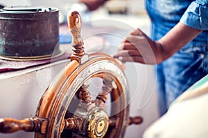 The hands of the captain and a steering wheel boat port services. Sea and travel concept