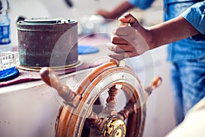 The hands of the captain and a steering wheel boat port services. Sea and travel concept