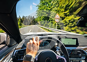 Hands of car driver on steering wheel, road trip, driving on highway road