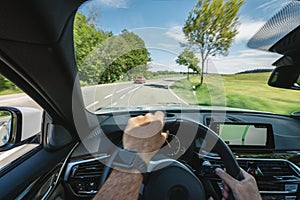 Hands of car driver on steering wheel, road trip, driving on highway road