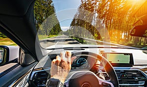 Hands of car driver on steering wheel, road trip, driving on highway road