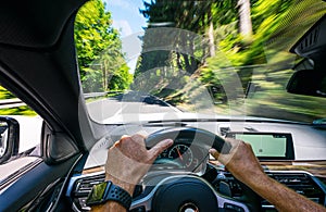 Hands of car driver on steering wheel, road trip, driving on highway road