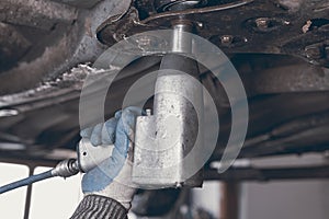 Hands of car mechanic in auto repair service.