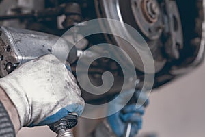 Hands of car mechanic in auto repair service.