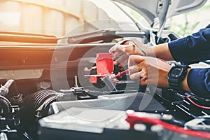 Hands of car mechanic working in auto repair service.