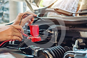 Hands of car mechanic working in auto repair service.