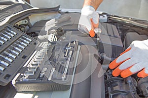 Hands of car mechanic with wrench in garage. Auto Repair and care Concept
