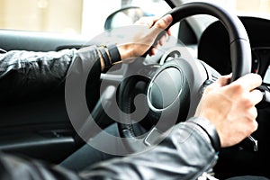 Hands on car steering wheel