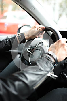 Hands on car steering wheel