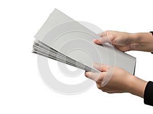 Hands carefully holding a stack of light gray paper sheets