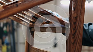 Hands of a carpenter cover up wood of black stain. Carpentry work. Joinery industry. Woodwork manufacturing.