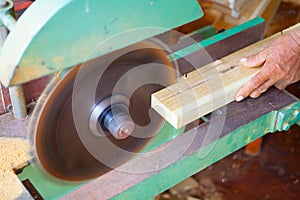 hands of the carpenter or craftsman cut a piece of wood to Machine Electronic Table Circular saw blade