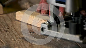 Hands of carpenter planed wood.