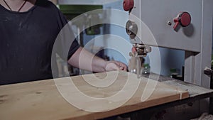 Hands of a carpenter saw wood in saw machine woodcraft