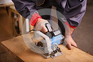 Hands carpenter working with a circular saw