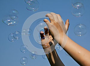 Hands catching bubbles