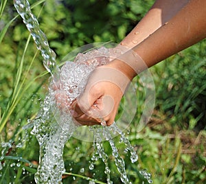 Hands catching clean falling water close up photo