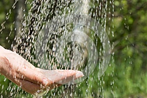 Hands catching clean falling water close up