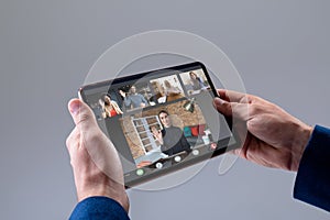 Hands of caucasian businessman making tablet video call, with five diverse colleagues waving photo